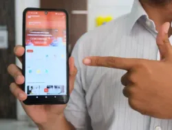 seorang pria menggunakan aplikasi sentuh tanahku di ponsel saat berada di kantor pertanahan