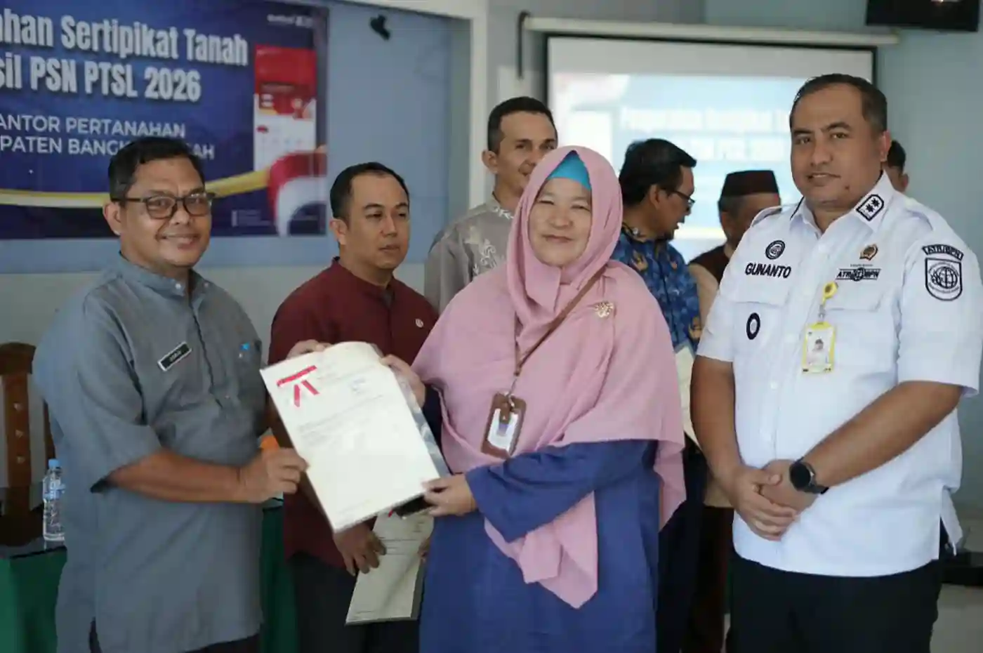 warga bangka tengah memegang sertipikat tanah gratis dari program ptsl
