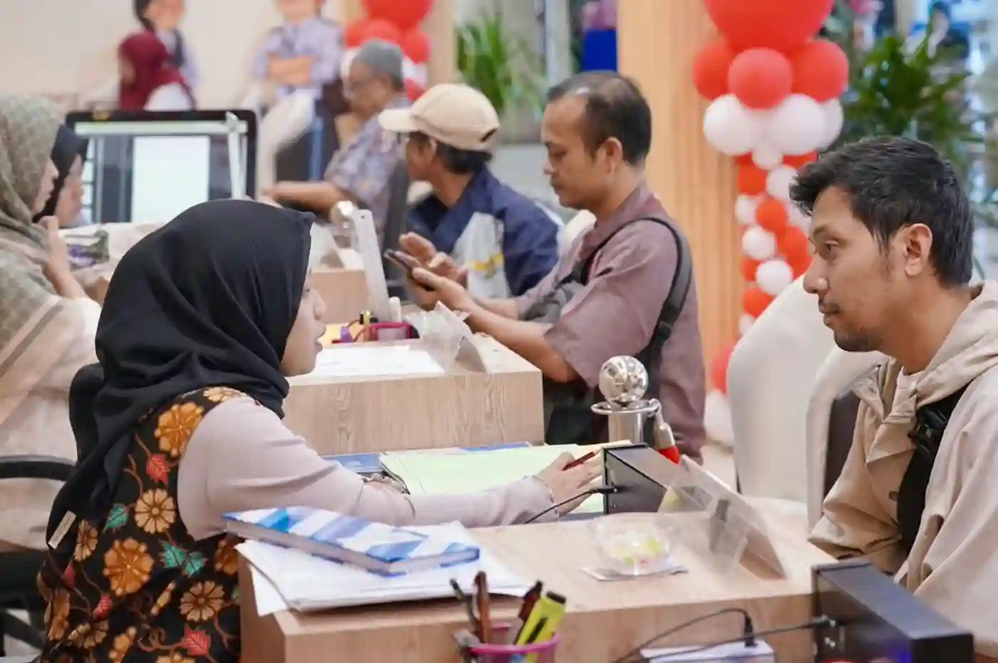 warga sedang berkonsultasi dan mengurus dokumen di loket layanan pelataran kantor pertanahan makassar pada akhir pekan