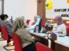 warga sedang menerima pelayanan sertipikat tanah di loket kantor pertanahan